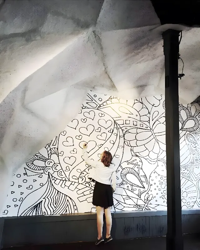 An artist illustrating on a wall