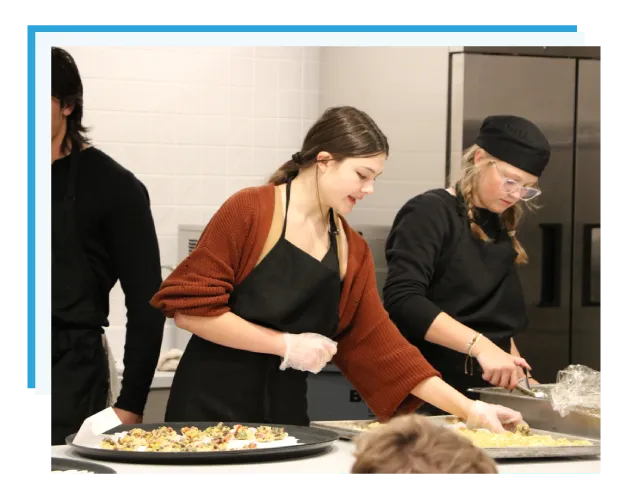 A student cooking and preparing for the grand opening