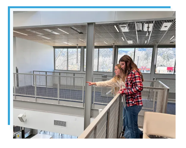 Two students looking out over the new space from the second floor