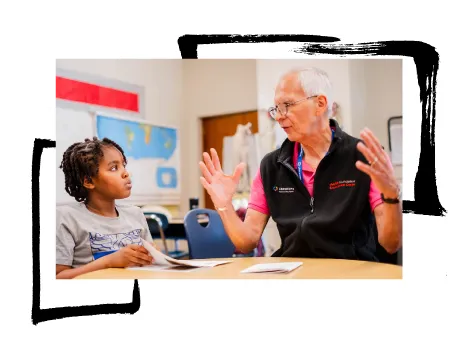 A retired adult speaking with a student